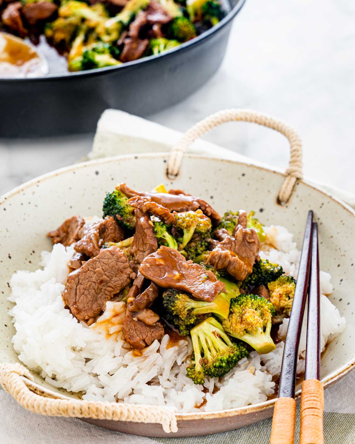 beef and broccoli over a bed of rice ina plate
